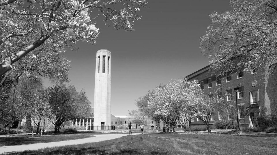 Black and white photo of students walking near Mueller Tower